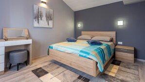 A modern bedroom with a wooden bed, bedside tables, a desk with a chair, and a large painting on the wall. - Villa Vita in Poreč  - Haus für 6-8 Personen (Kaštelir)