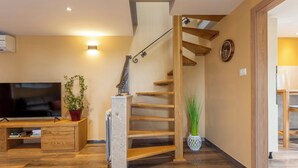 A modern living room with a wooden staircase, a flat-screen TV, and a potted plant. - Villa Vita in Poreč  - Haus für 6-8 Personen (Kaštelir)