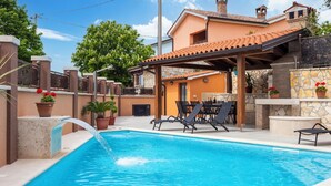 A swimming pool with a water feature, outdoor seating, and a covered patio area. - Villa Vita in Poreč  - Haus für 6-8 Personen (Kaštelir)