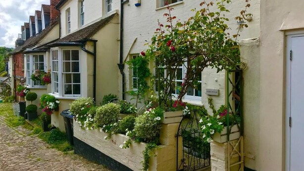 A row of traditional buildings with flower boxes and a cobblestone street. - Beautiful 17th Century Coach House (Marlborough)