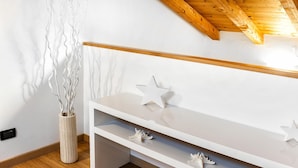 A modern room with a white console table, decorative star-shaped objects, and a tall vase with branches.
