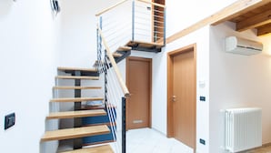 A staircase with wooden steps and metal railings, a wooden door, and a white radiator.