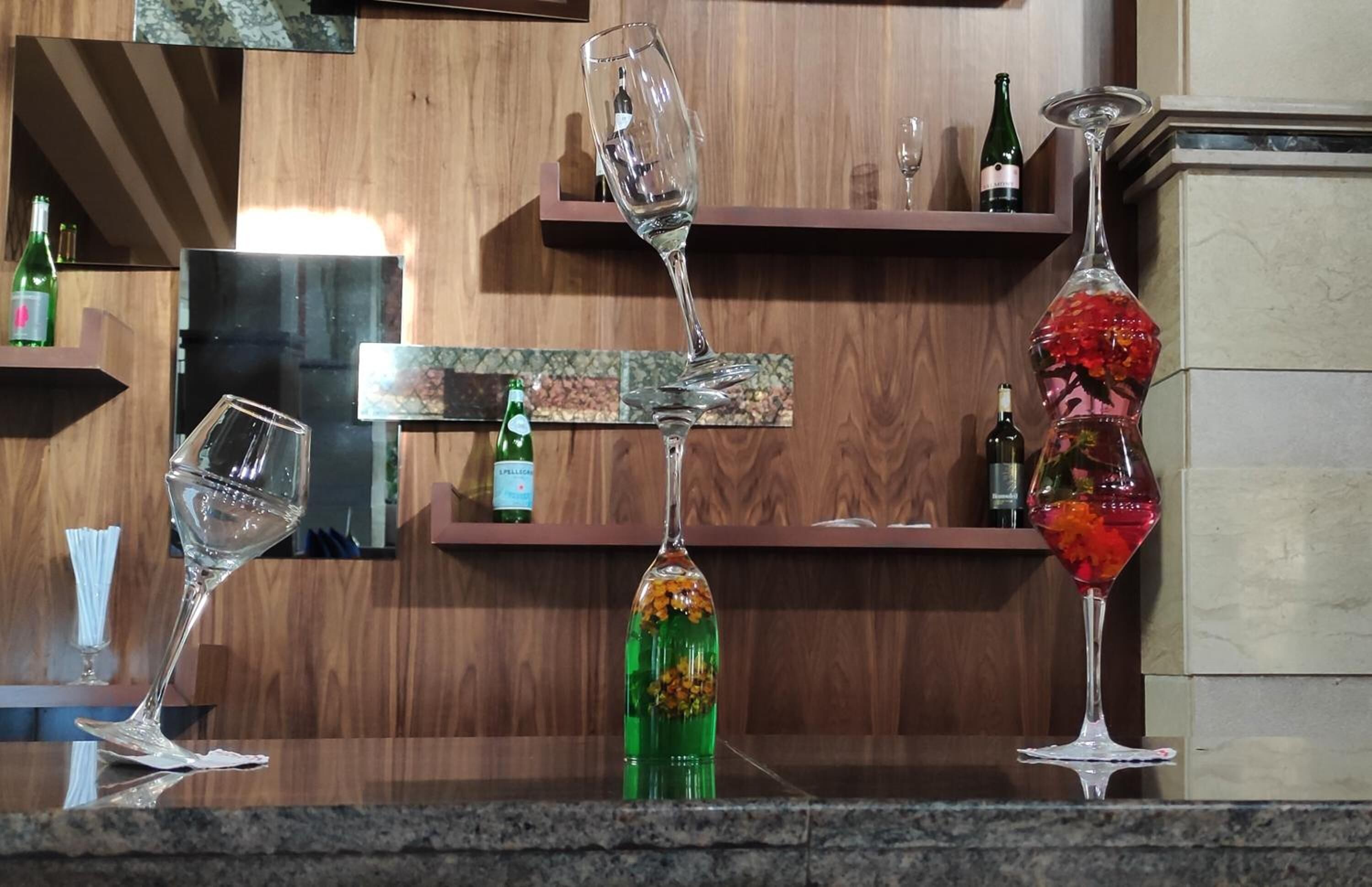 A bar area with various glassware and bottles on shelves.