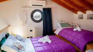 A bedroom with two beds, a window, and an air conditioning unit.