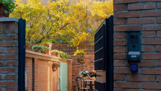 A brick building with a gate, a small table with chairs, and a sign with the number "801".