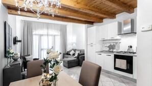 A modern kitchen with white cabinets, a gas stove, and a stainless steel range hood. - Starfish 4         . (Venezia)