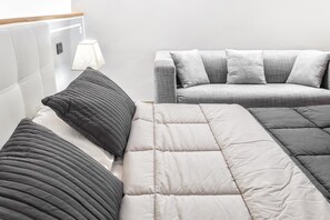 A modern bedroom with a bed, a sofa, and a lamp. - Starfish 4         . (Venezia)