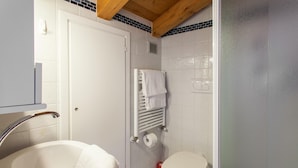 A bathroom with a white sink, a toilet, and a towel rack.