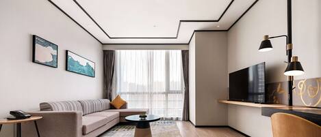 Una sala moderna con un sofá, una mesa de centro, un televisor y una silla.