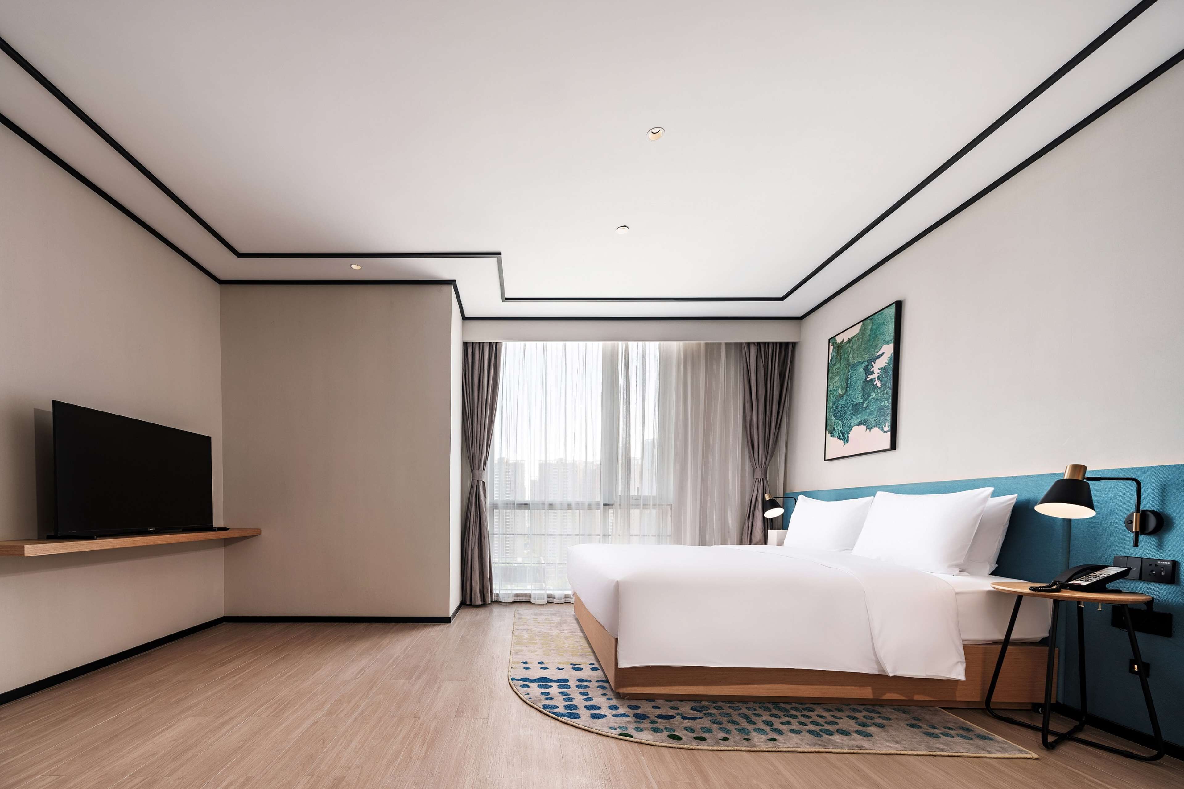 Una moderna camera d'albergo con un letto, una televisione su uno scaffale, una scrivania con una lampada e un'ampia finestra con tende.