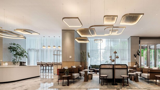 A modern hotel lobby with a reception desk, seating area, and large windows. - Hilton Garden Inn Hefei Binhu New District (Hefei)