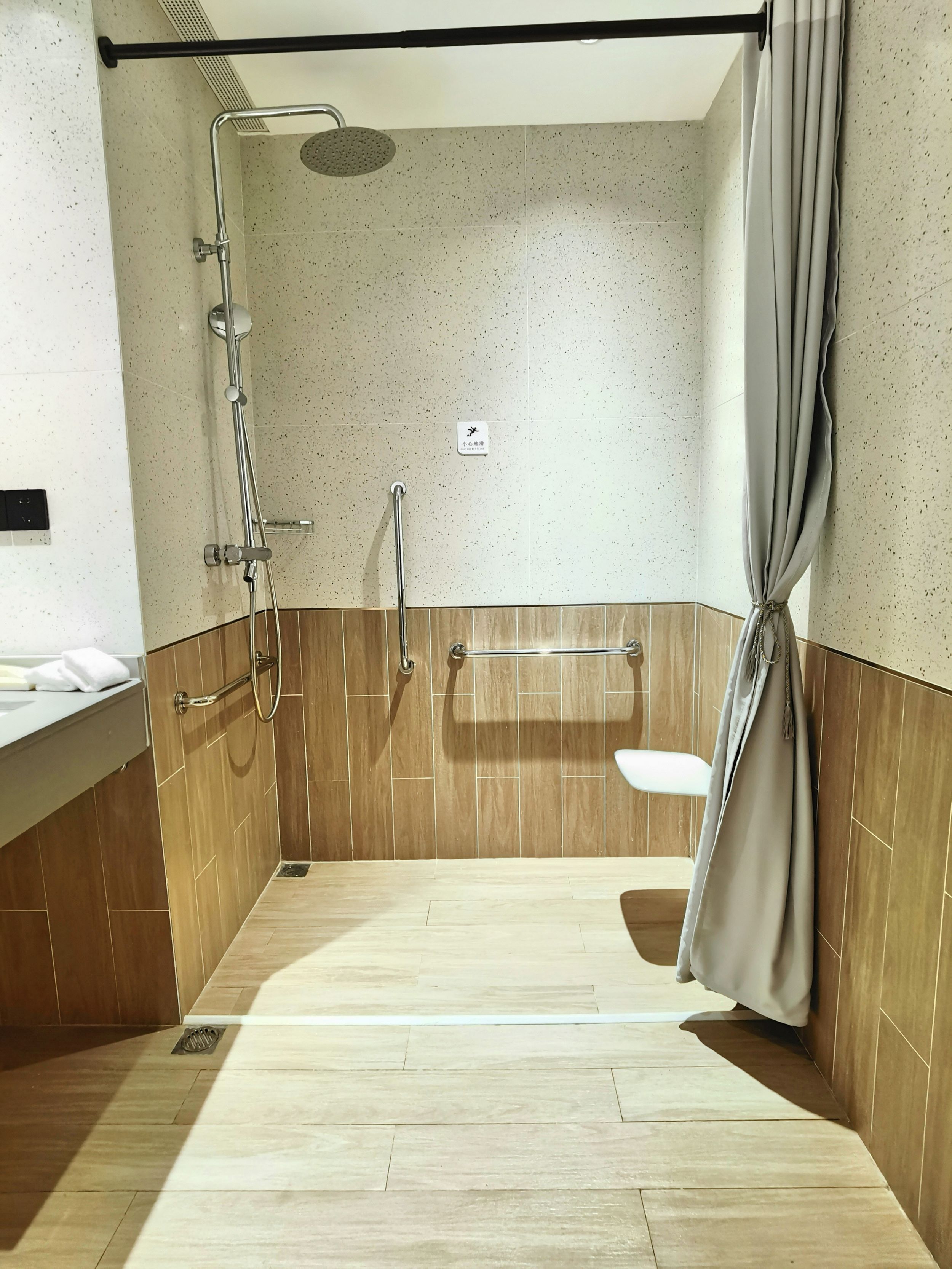 A modern bathroom with a shower, a toilet, and a sink.
