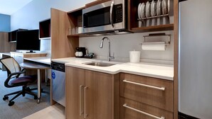 A modern kitchen with a microwave, sink, and dishwasher. - Home2 Suites by Hilton Lincolnshire Chicago (Lincolnshire)