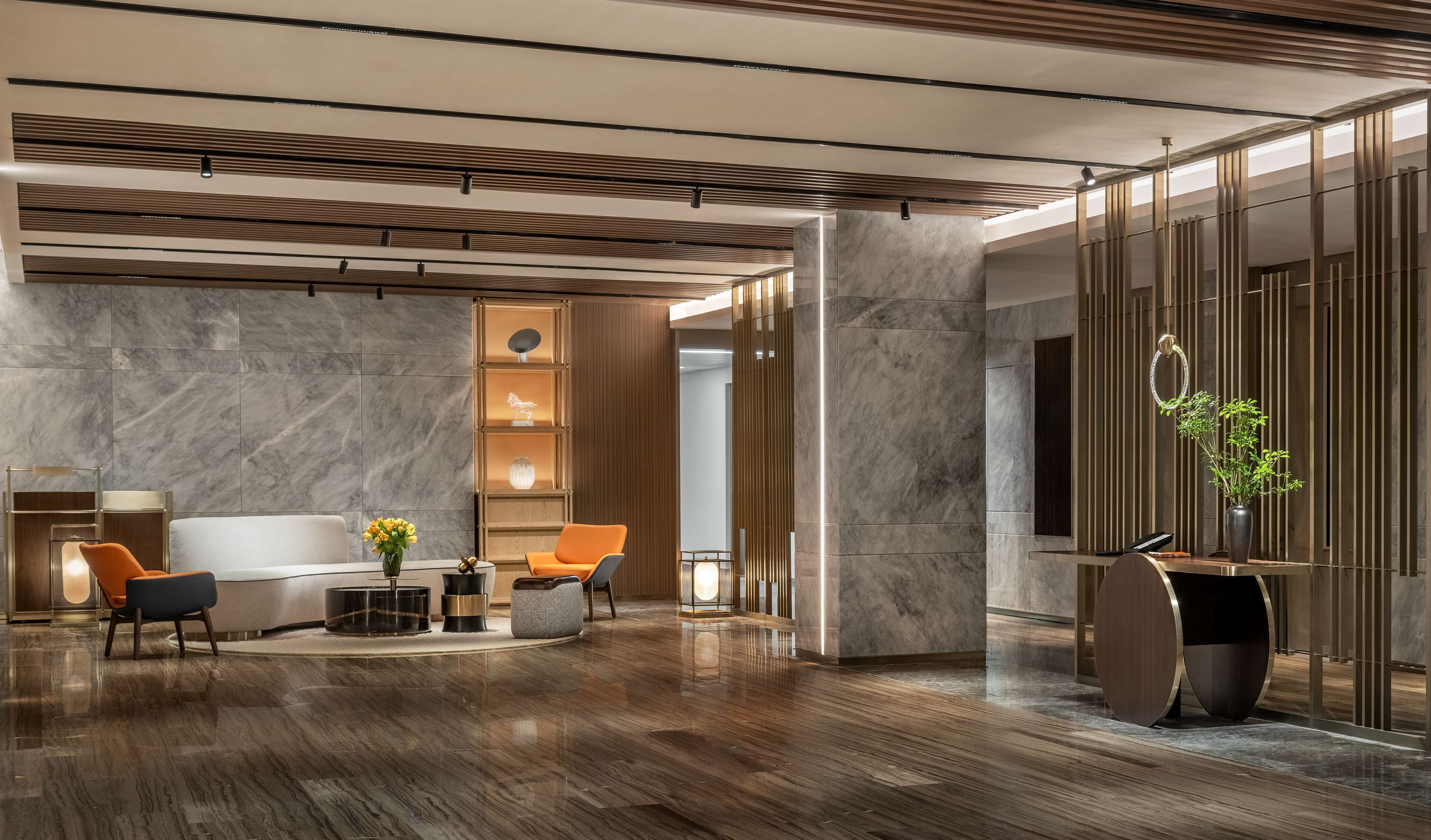 A modern lobby with a marble floor, wooden accents, and contemporary furniture.