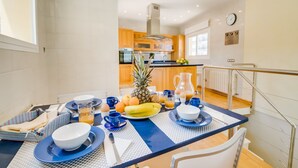 Een ontbijt opstelling met een tafel, ontbijtartikelen en een keuken op de achtergrond.