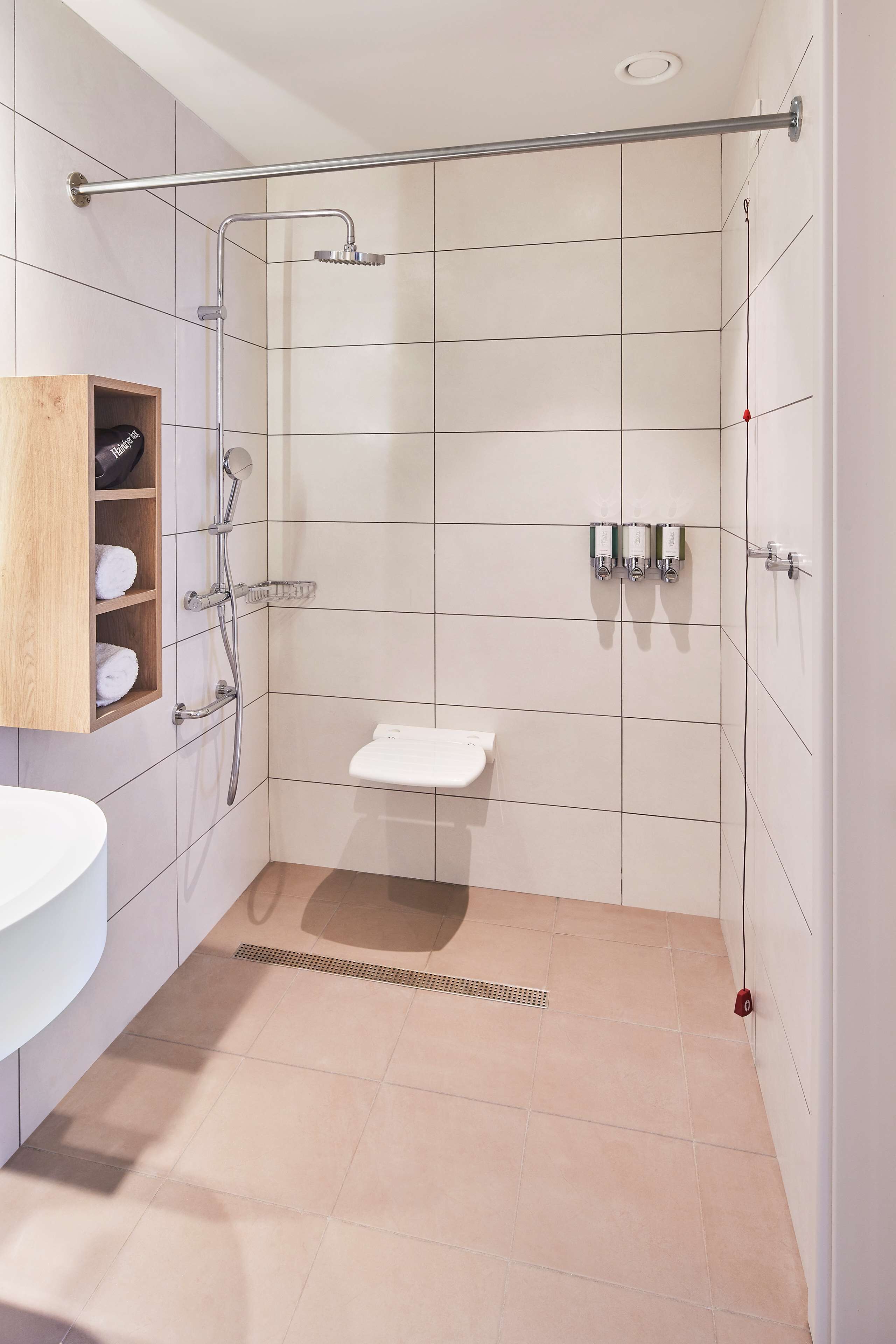 A modern bathroom with a shower, toilet, and sink.