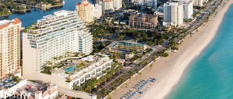 Ein Hotel an der Küste mit mehreren Gebäuden, einem Strand und einer Marina.