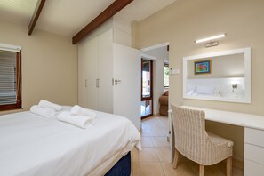 A hotel room with a bed, a desk, and a chair. - San Lameer Villa Rentals 2851 (Southbroom)