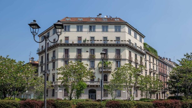 A multi-story building with a classical architectural style, featuring a symmetrical facade, multiple balconies, and a central entrance. - Sweett | Arco della Pace (Milano)