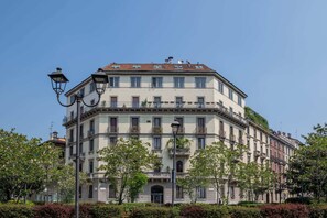 Ein mehrgeschossiges Gebäude im klassischen Stil mit einer symmetrischen Fassade, mehreren Balkonen und einem zentralen Eingang.