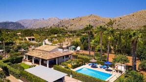 A villa with a swimming pool, surrounded by lush greenery and mountains in the background. - Villa Pantina, 2 bedroom villa near Pollensa (Port de Pollença)