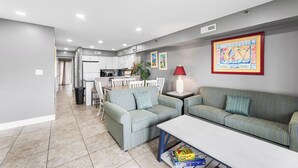 Ein modernes Wohnzimmer mit einer Couch, einem Couchtisch und einem Essbereich mit Stühlen und einem Tisch.