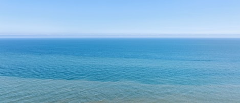 A beach with clear blue water and a sandy shore.