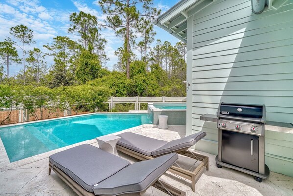 A poolside area with lounge chairs, a barbecue grill, and a swimming pool. - WaterColor Retreat: Private Pool, Golf Cart, Bikes, and Serene Luxury! (Santa Rosa Beach)