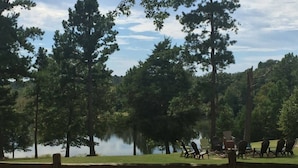 Un parc au bord du lac, doté d’une clôture en bois, de tables de pique-nique et de chaises.