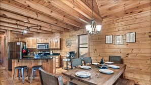 L’intérieur d’une cabane en bois comprend un coin repas, une cuisine et un bar.