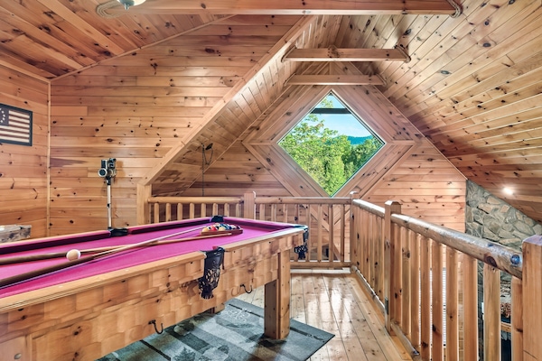 Loft with 6 foot pool table and multi-game arcade machine.