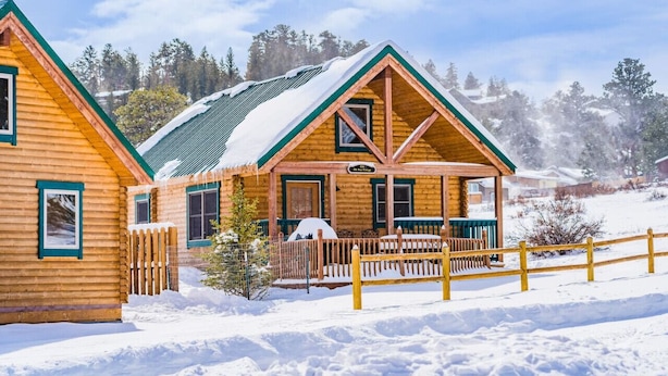 A log cabin with a green roof, a porch, and a sign that reads "The New Center." - Elk Hotspot w/ Views, Deck & Game Room (Estes Park)