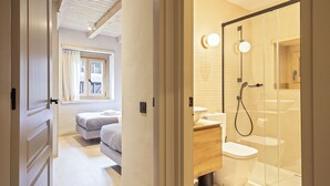 A modern bathroom with a glass shower enclosure, a toilet, and a sink. - Luderna - Apartamento con jardín Crabera (Arties)