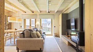 A cozy living room with a sofa, a television, and a fireplace. - Luderna - Apartamento con jardín Crabera (Arties)