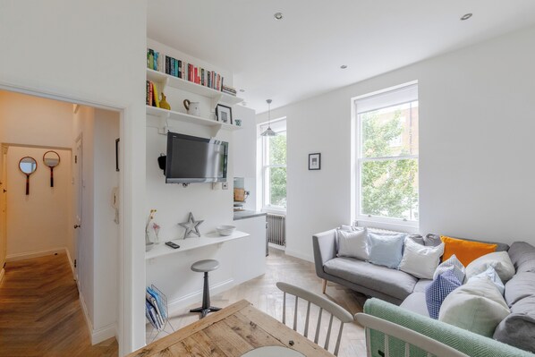 A modern living room with a sofa, a television, and a bookshelf.