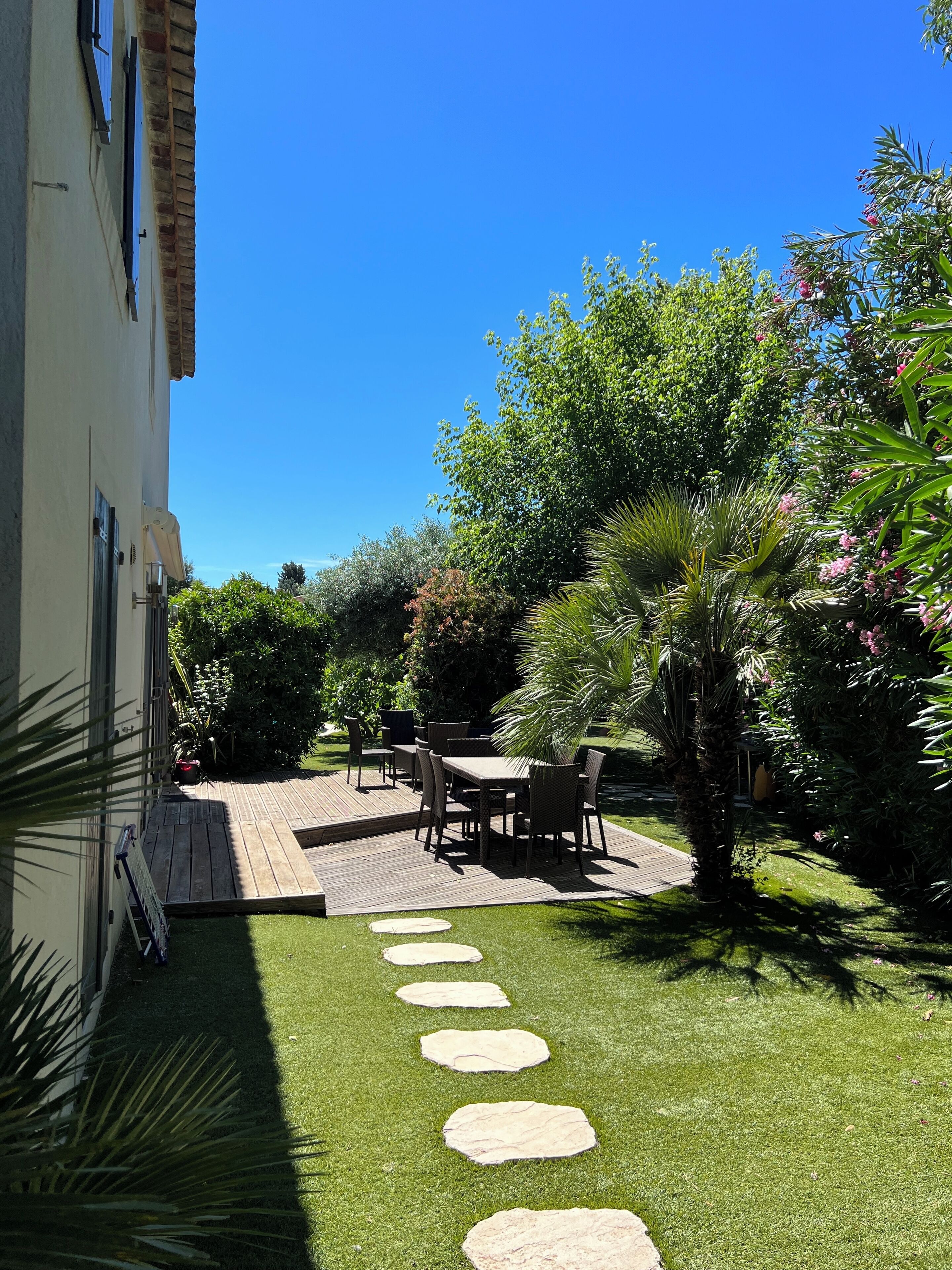 A patio with outdoor furniture and a stone pathway leading to a building.