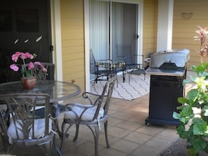Enjoy al fresco dining on the patio, where a round table and four chairs await, accompanied by a grill and a beautiful potted plant.