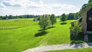 A rural landscape with a fenced field, a stone building, and a clear sky. - Great rates-2B-2B cabin by Fall Creek Falls-Amazing views with hot tub&fire pit  (Spencer)