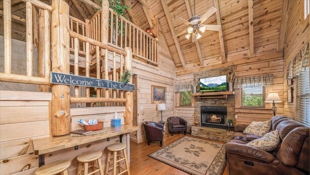 A cabin interior with a wooden exterior, a bar area, a fireplace, a sofa, and a ceiling fan. - Great rates-2B-2B cabin by Fall Creek Falls-Amazing views with hot tub&fire pit  (Spencer)