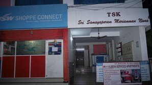 A commercial building with a blue sign for 'Shoppe Connect' and a white sign for 'TSK'. - Kubera Service Apartments (Tiruchirappalli)