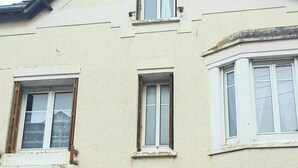 A two-story building with a symmetrical facade, featuring a central entrance with a brick lintel and a door. - HOUSE in the center of Fécamp - 90 M2 (FECAMP)