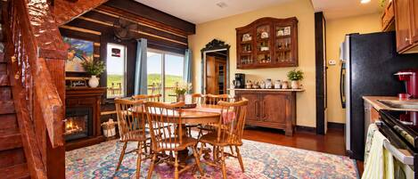 A spacious kitchen with a dining area, wooden cabinets, and a large window.