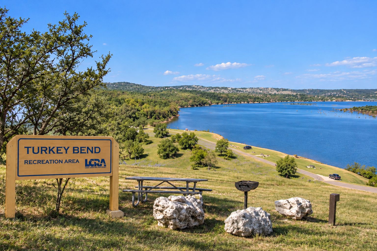 Señal del área recreativa Turkey Bend, con una mesa de picnic y rocas cerca.