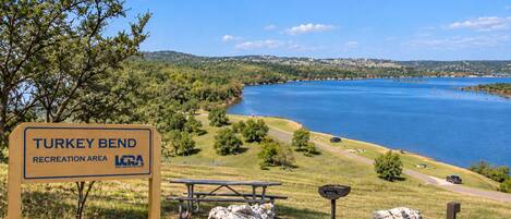Señal del área recreativa Turkey Bend, con una mesa de picnic y rocas cerca.