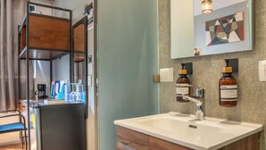 Een moderne badkamer met een houten wastafelmeubel, een grote spiegel en een inbouwgootsteen.