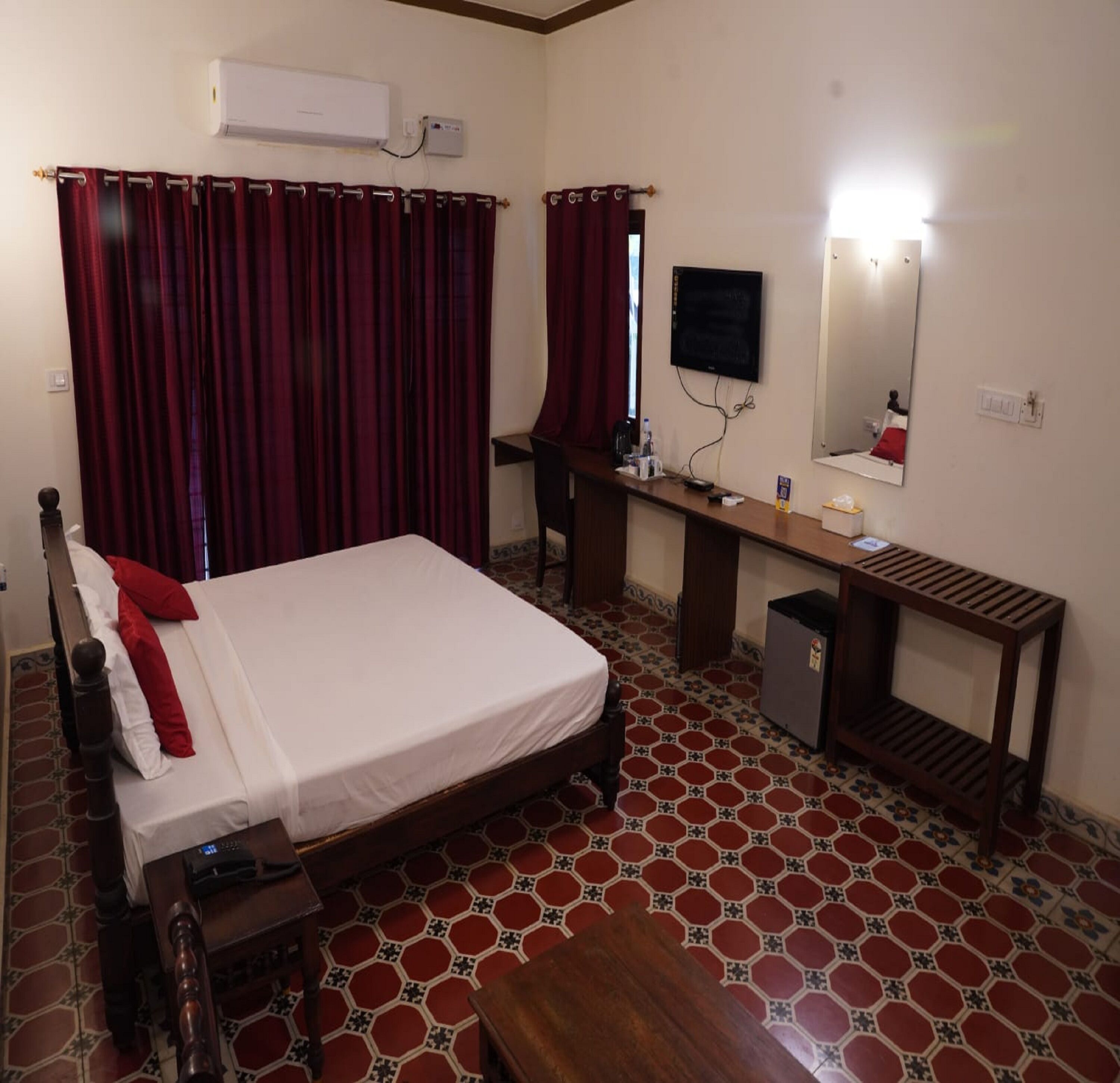 Une chambre d’hôtel comprenant un lit, un bureau, une chaise, une télévision et un miroir.