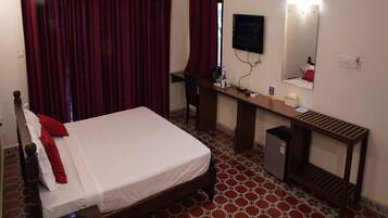 Une chambre d’hôtel comprenant un lit, un bureau, une chaise, une télévision et un miroir.