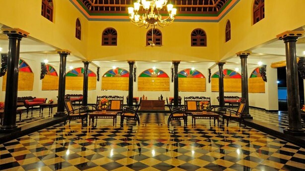 A lobby with a checkered floor, a chandelier, and a reception desk. - Thappa Gardens Resort (Karaikudi)
