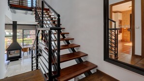 Eine moderne Treppe mit Holzsitzstufen und schwarzen Geländern, die zu einer oberen Etage führt.