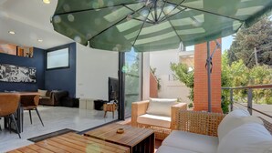 Ein modernes Wohnzimmer mit einer Couch, einem Holztisch und Korbstühlen.